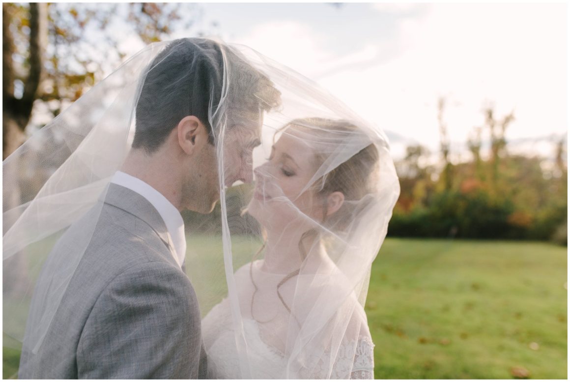 bride and groom kissing under veil at graeme park