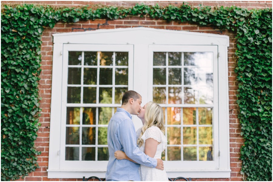 couple kissing in front of window at longwood gardens