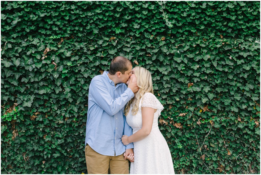couple kissing in front of vine wall at longwood gardens