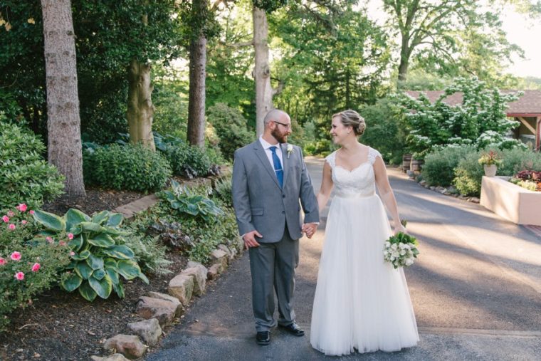 bride and groom walking into sunlight at meredith manor